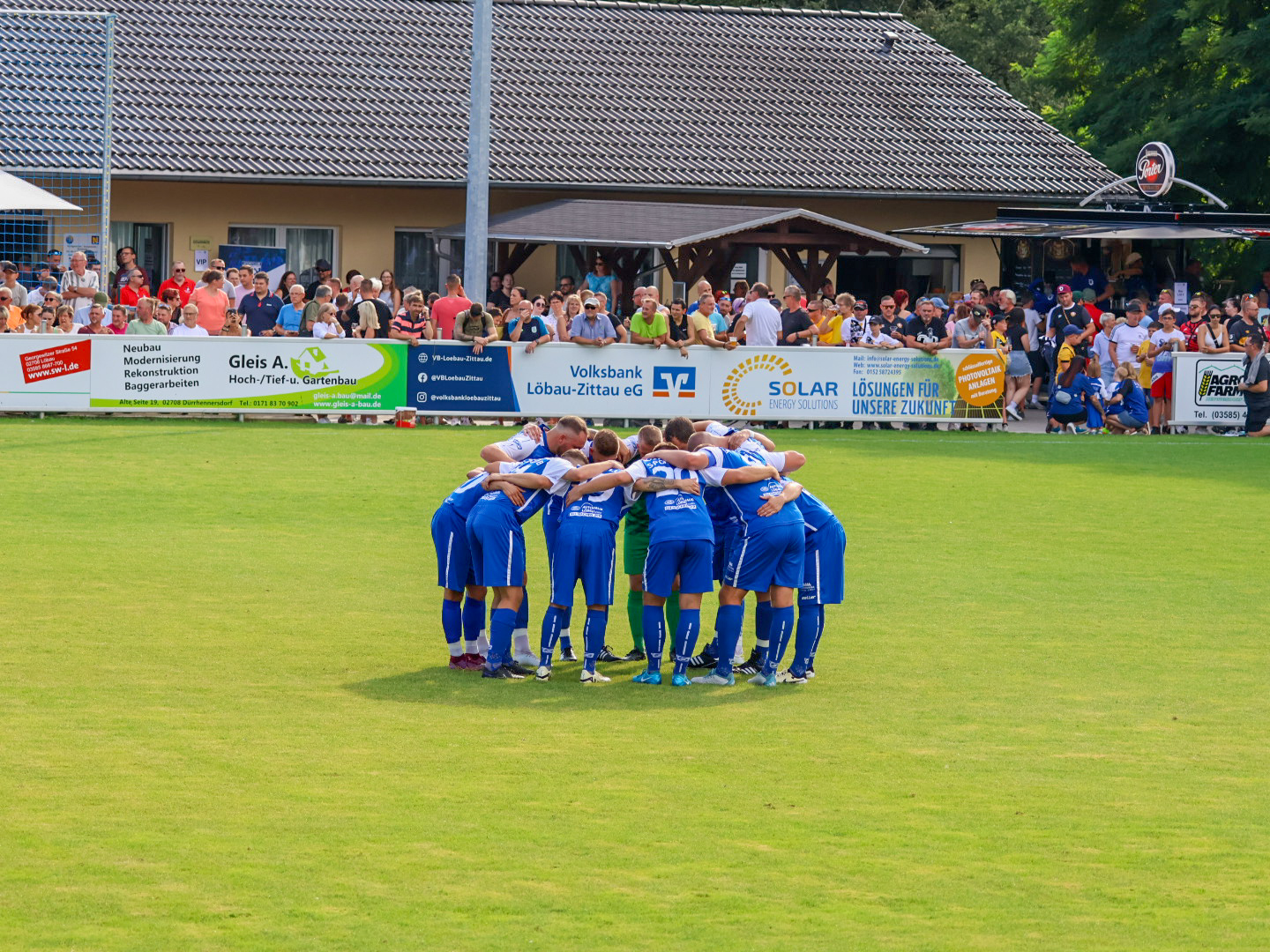 Männerfußballmannschaft in Trikots posiert auf dem Spielfeld. Teamgeist im Sportclub Großschweidnitz - Löbau e.V.